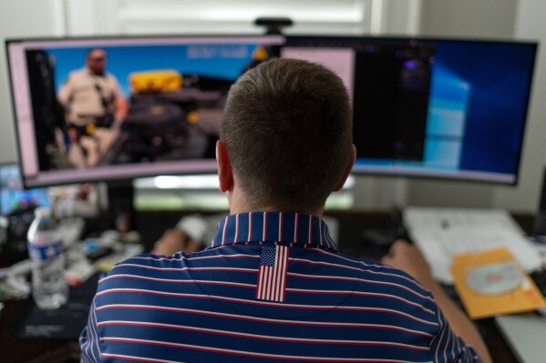 Alek Schott watches police body camera video of his vehicle search, Thursday, Oct. 16, 2025, while sitting at his home in Houston. (AP Photo/David Goldman)