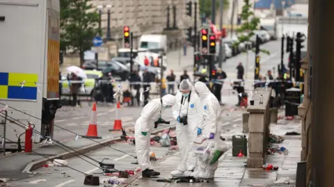 EPA Three forensic officers, wearing white overalls and blue masks, are at the scene where a car collided with fans during the Liverpool FC Cup parade in Liverpool city centre.