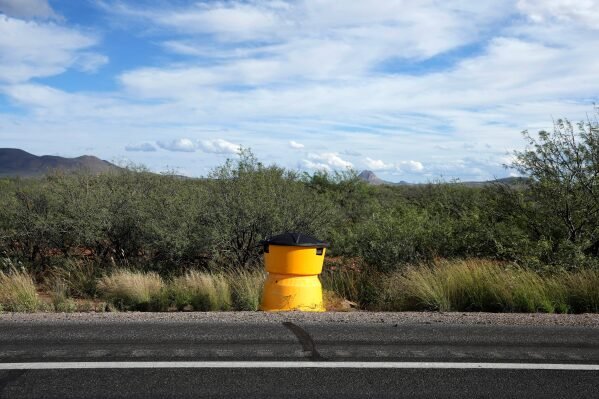 A license plate reader used by U.S. Border Patrol is hidden in a sand crash barrel along the state Highway 80, Thursday, Oct. 23, 2025, in Douglas, Ariz. (AP Photo/Ross D. Franklin)