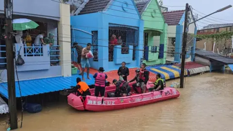 Reuters Rescue teams distribute supplies to stranded people in a flooded area in Hat Yai