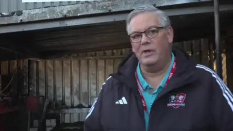 Man, Exeter City manager Clive Harrison wearing a black coat and glasses