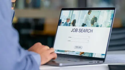 AFP via Getty Images A man looking at a jobs website