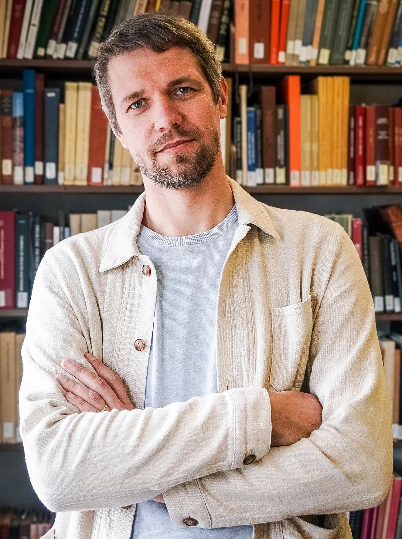 The image may contain a book inside, library publications, adult furniture, a bookcase, a face and a head