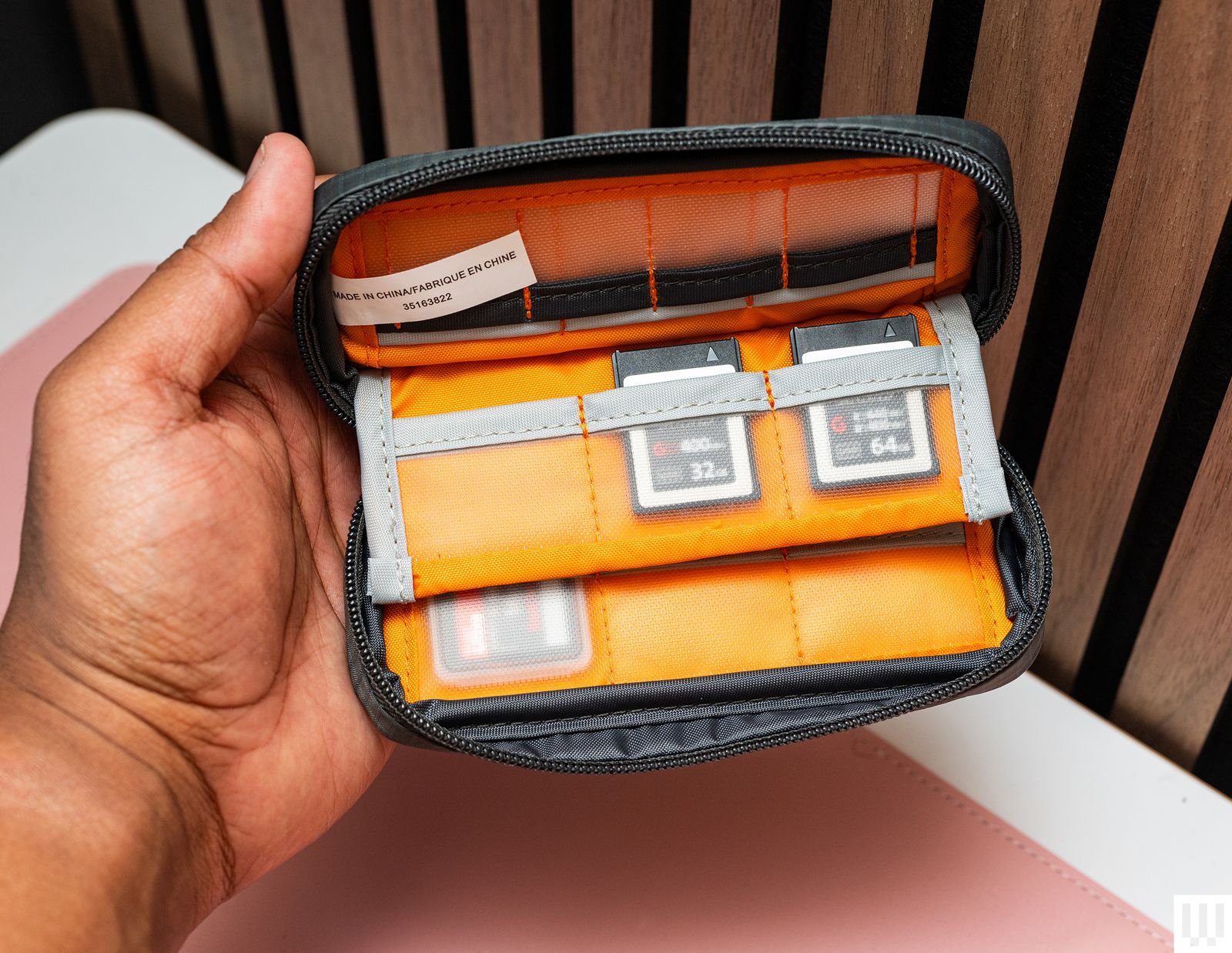 Hand holding the Lowepro GearUp Memory Wallet showing the interior slots with camera memory cards inside