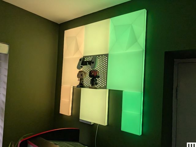 Nanoleaf Blocks, illuminated panels installed on an interior room wall glowing with yellow and green light