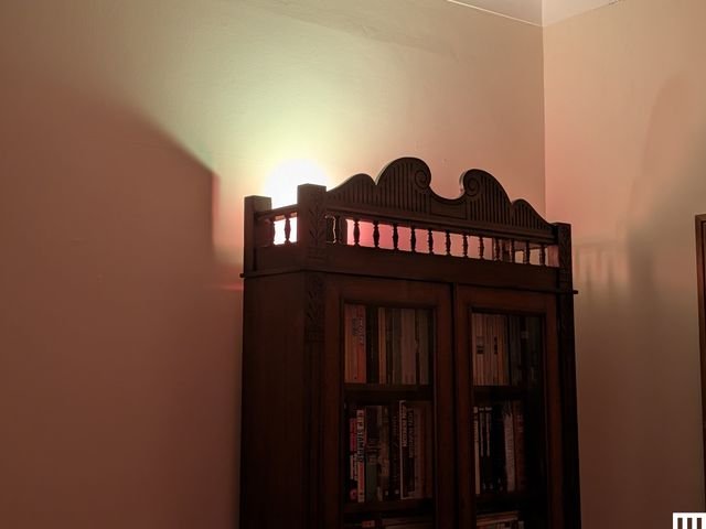 Tall wooden wardrobe emitting soft light from the top
