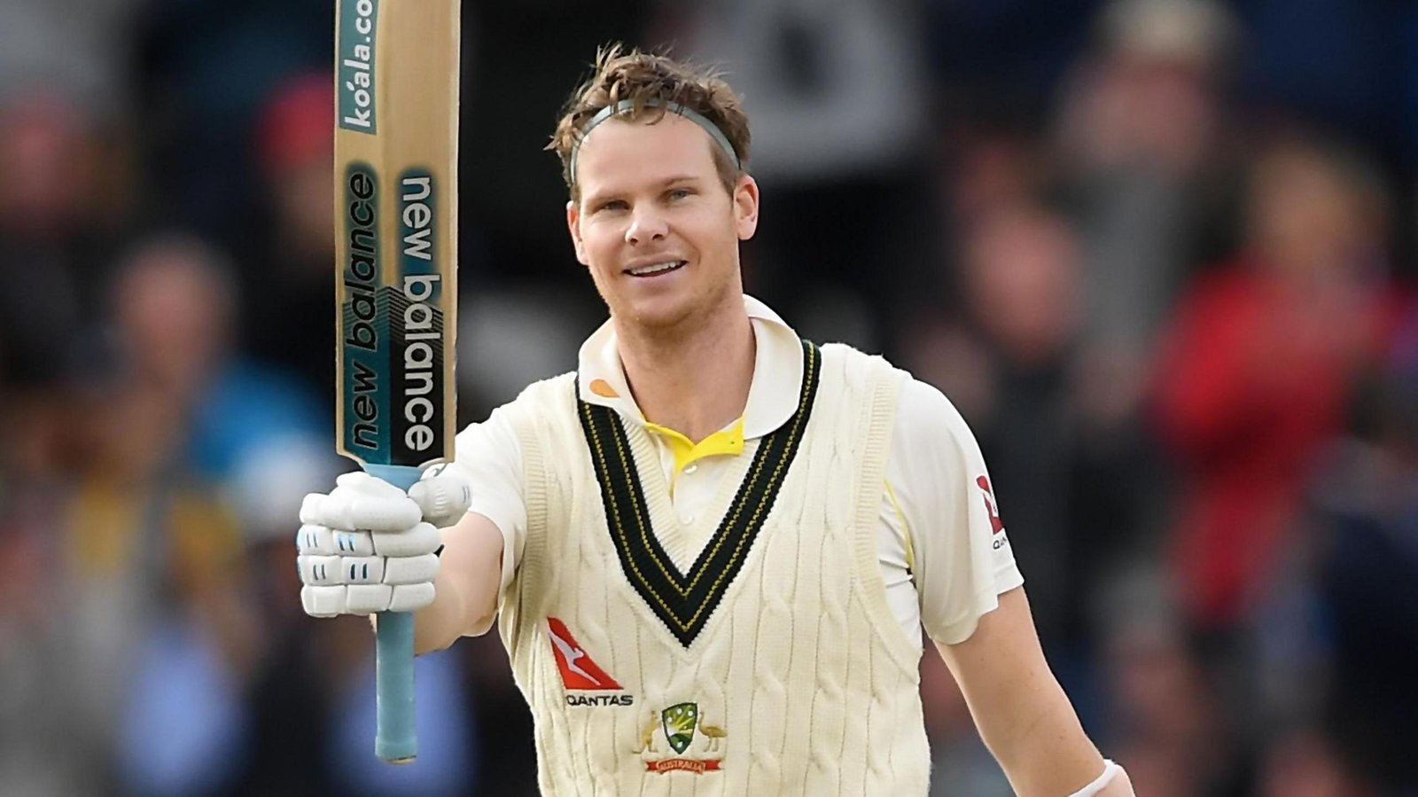 Steve Smith holds his bat high and smiles