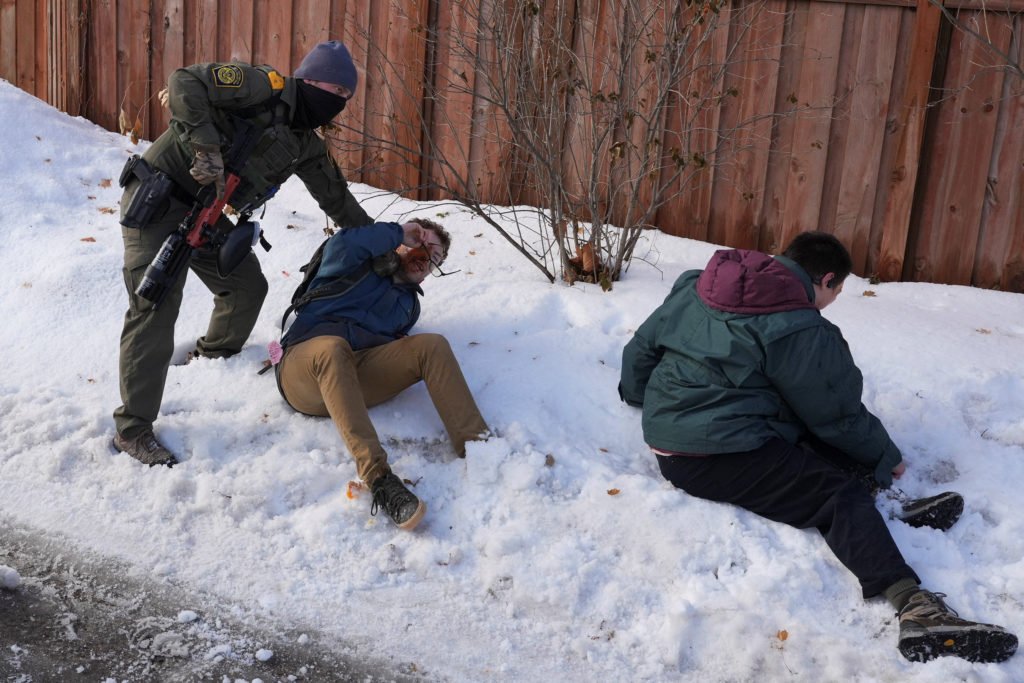Members of US Immigration and Customs Enforcement (ICE) stand guard after a motorist was shot in Minneapolis
