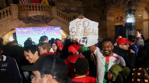 Bloomberg via Getty Images An attendee holds a "Go Senegal" Signing during the viewing ceremony of the African Cup of Nations final match with Zahran Mamdani, Mayor of New York,