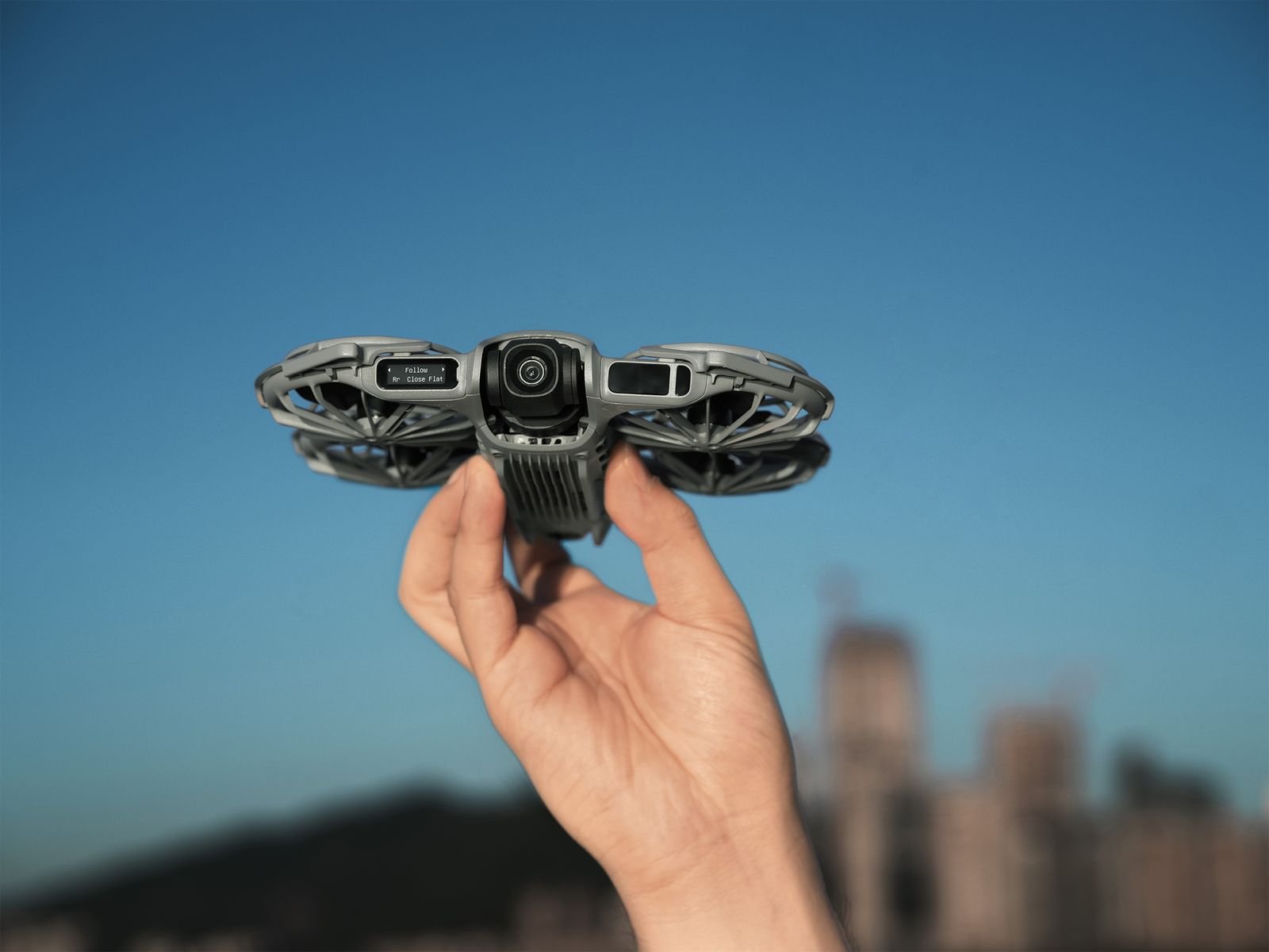 Hand holding a small drone with four circular areas