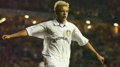 Getty Images A young Alan Smith celebrates a Leeds United goal with his arms outstretched. He has spiky blonde hair and a crest 
