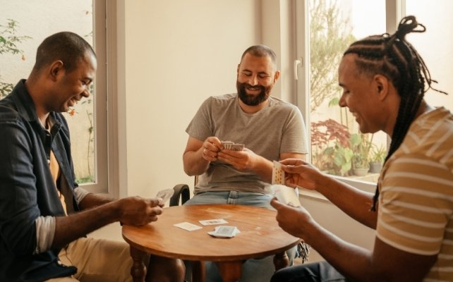 three men at a table playing a card game