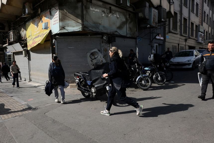 People run for cover following an explosion in Tehran, on Saturday, February 28.