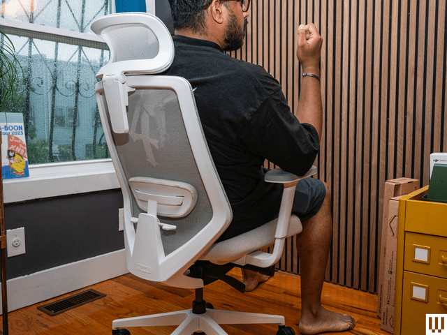 Image may contain: indoor design, chair, furniture, adult, person, wood and solid