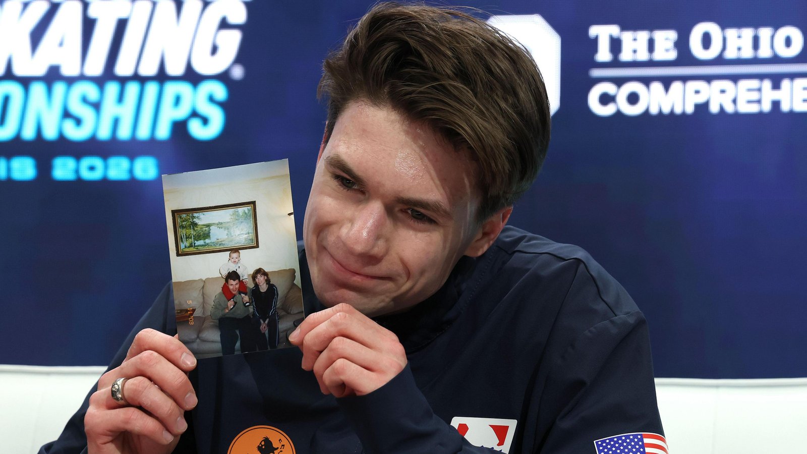 Maxim Naumov holds a photo of his parents after competing in the men