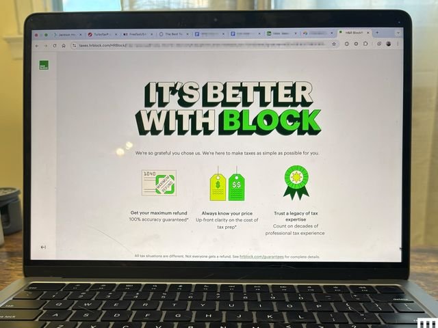 Close-up of an open laptop with a screen showing H&R Block tax filing software