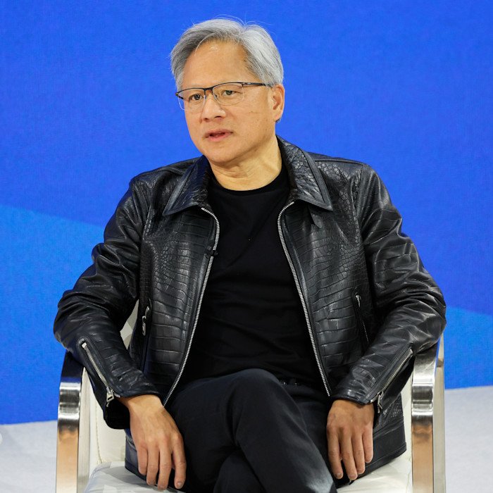 Jensen Huang sits on stage in a black leather jacket during the New York Times DealBook summit