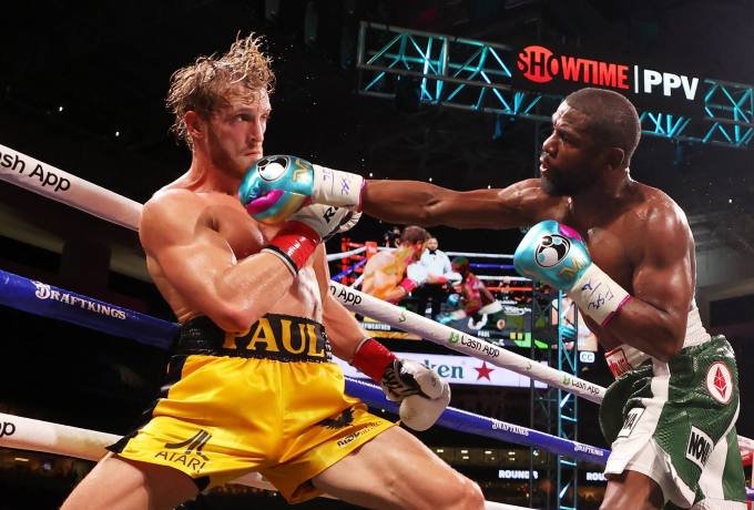 Floyd Mayweather punches Logan Paul during their contracted exhibition boxing match at Hard Rock Stadium