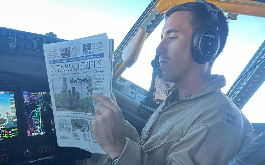 A service member reads the newspaper.