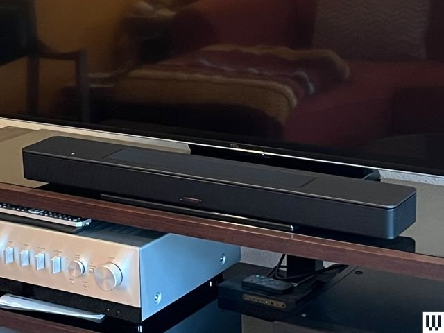 The Bose Smart Soundbar, a long, narrow black device, sits at the base of a large flat-screen TV