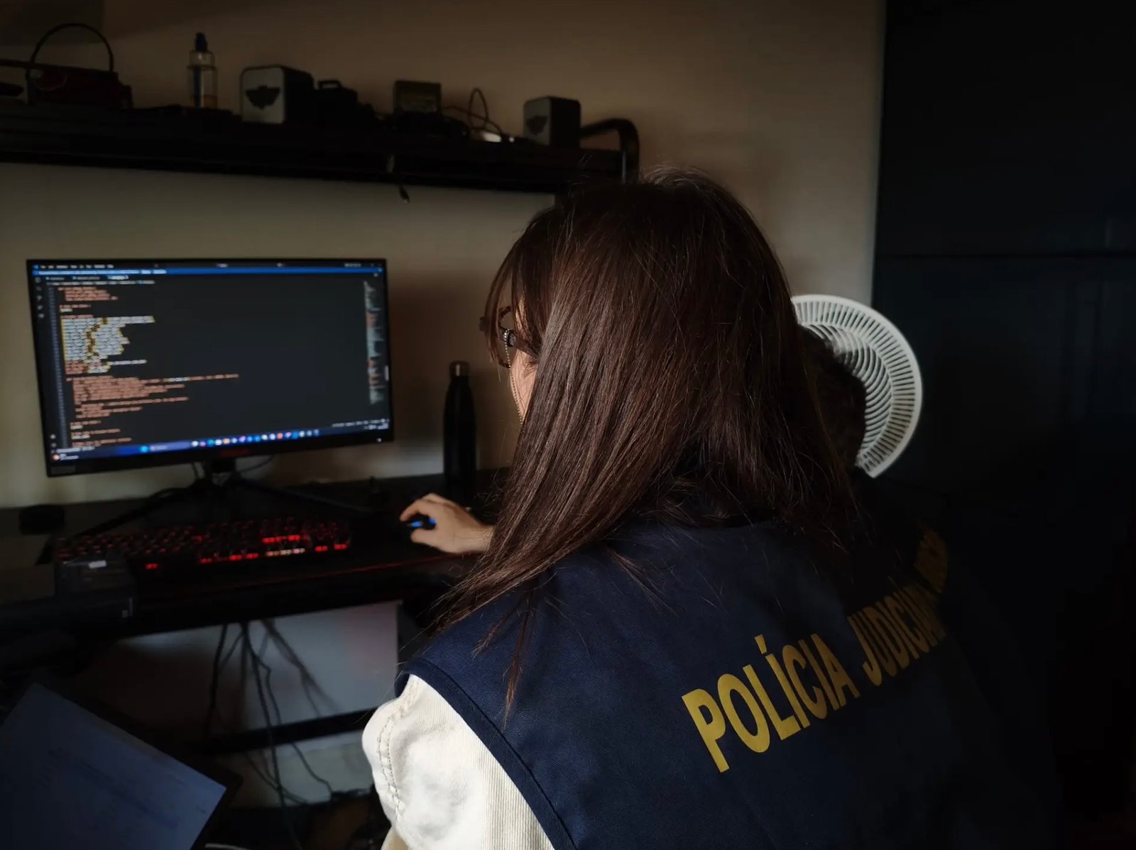 Image of a European police officer checking a computer at a forum member